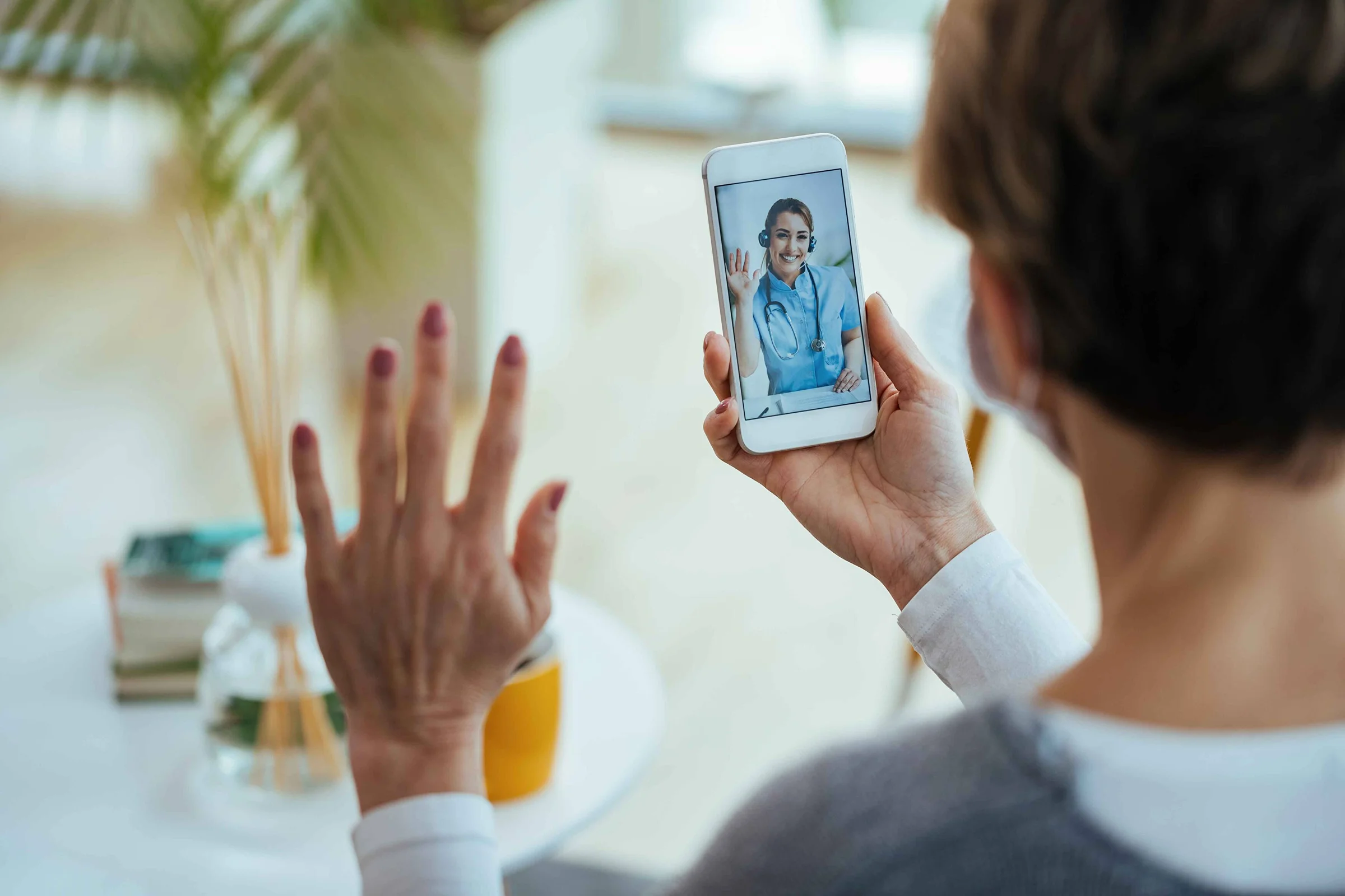 closeup-woman-greeting-her-doctor-while-using-smart-phone-having-video-call-focus-is-female-doctor-touchscreen_11zon_1770801721